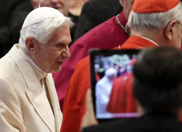 A Catholic devotee takes a picture of the former head of the Roman Catholic Church, Pope Benedict XVI.
