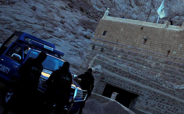 Special police forces stand guard as a Greek monk is seen on the top of a church at Saint Catherine's monastery, in the Sinai Peninsula, south of Egypt, in this file photo taken December 8, 2015.