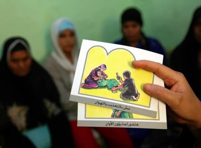 A counselor holds up cards used to educate women about female genital mutilation in Minia, Egypt, June 13, 2006.