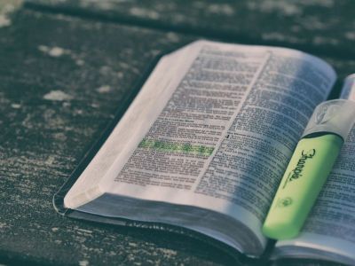 A Bible with highlighted verses lies open on a table.