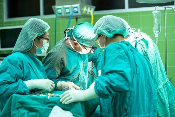 A group of medical professionals perform surgery in a hospital. 