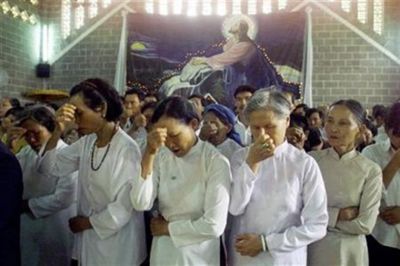 Vietnamese women make the sign of the cross during a mass at a church in Buon Ma Thuot, Vietnam.