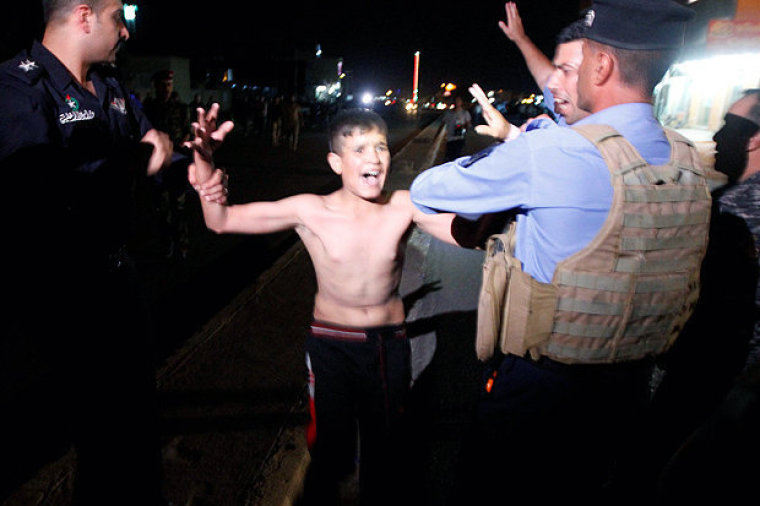 Iraqi security forces detain a boy after removing a suicide vest from him in Kirkuk, Iraq, August 21, 2016.