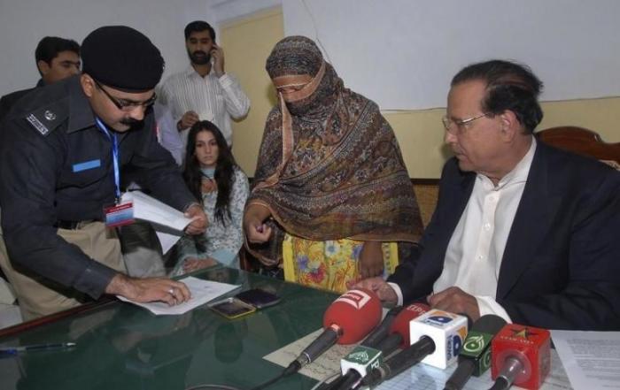 A police official takes the thumb print of Asia Bibi on an affidavit stating her innocence after she was visited by the Governor of the former Punjab Province, Salman Taseer