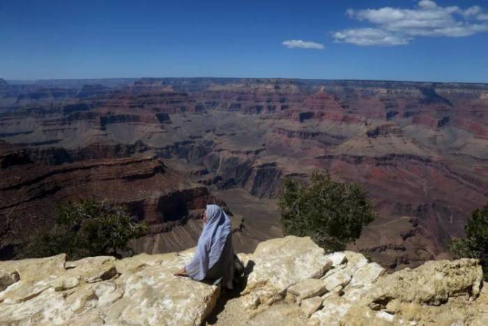 A woman sits on the south rim of Grand Canyon National Park in northern Arizona.