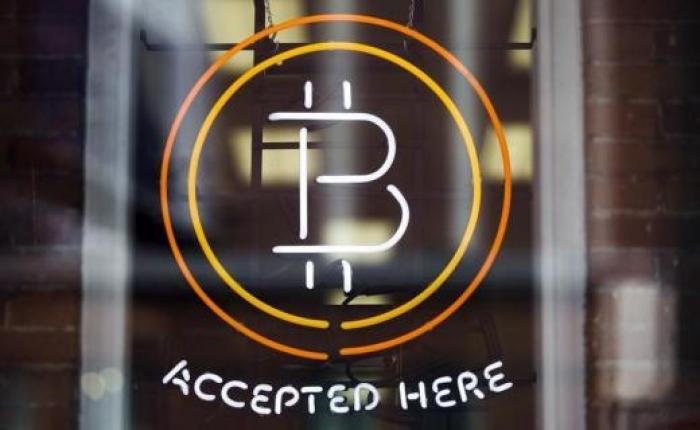 A Bitcoin sign is seen in a window in Toronto, May 8, 2014.