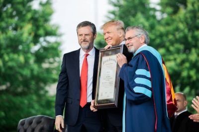 President Trump receives an honorary doctorate law degree from Liberty University President Jerry Falwell, Jr. (left) and Chief Academic Officer Dr. Ronald Hawkins (right) following his commencement address to the 2017 graduates.