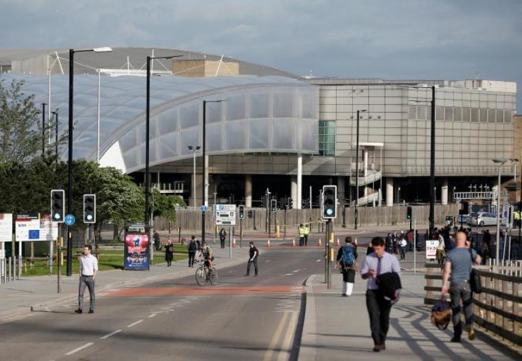 Commuters walk to work as a police cordon surrounds the Manchester Arena, Britain, May 23, 2017.