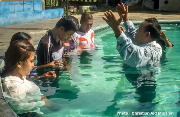 A pastor baptizes new Christian converts in Indonesia.