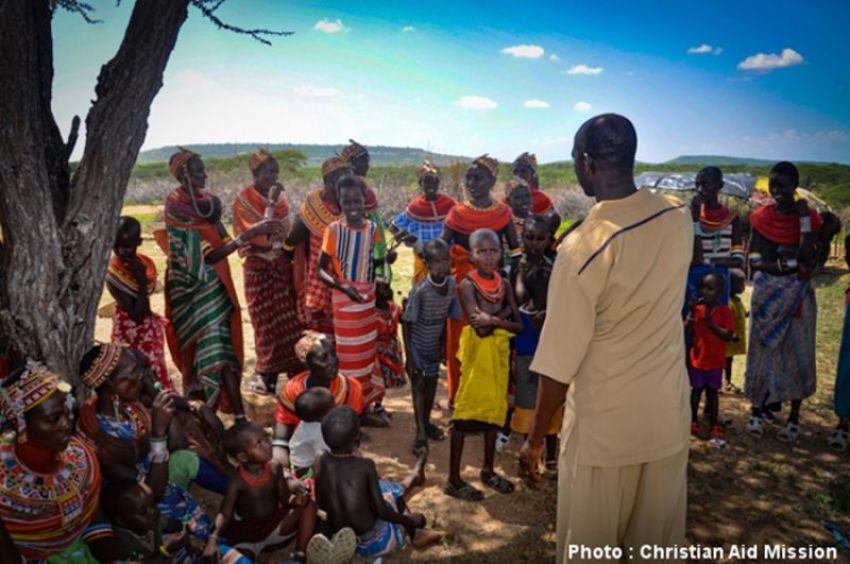 Kenyan villagers listen to a Christian ministry leader..