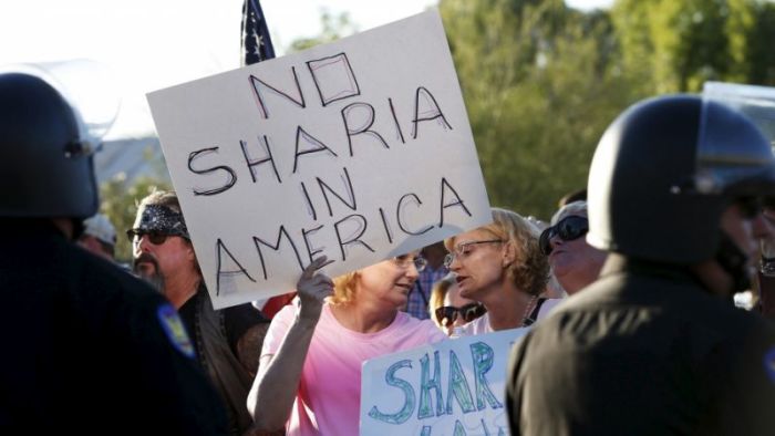 Anti-Muslim protesters at a rally in Phoenix, Arizona on May 29, 2015 pointed to Islamic sharia law as a problem for the United States. The sentiment is said to be a driving force behind failed legislation in Texas to ban foreign laws in American courts.