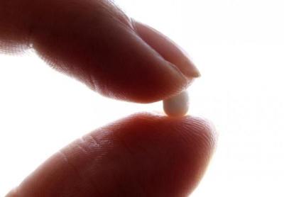 An illustration picture shows a woman holding a birth control pill at her home in Nice January 3, 2013.
