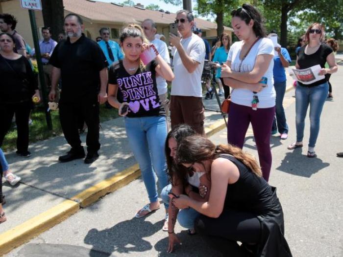 Chaldean-American Lavrena Kenawa (C, standing) cries as she thinks about her uncle who was seized on Sunday by Immigration and Customs Enforcement agents during a rally outside the Mother of God Catholic Chaldean church in Southfield, Michigan, U.S., June 12, 2017.