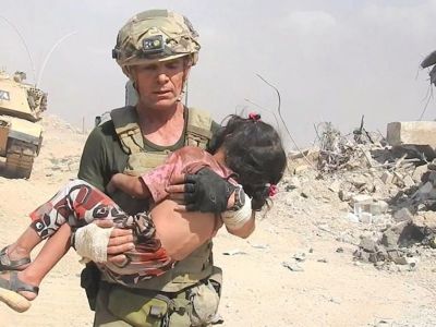 David Eubank of the Free Burma Rangers carries a young Iraqi girl who survived a massacre of civilians perpetrated by ISIS militants in Mosul, Iraq.