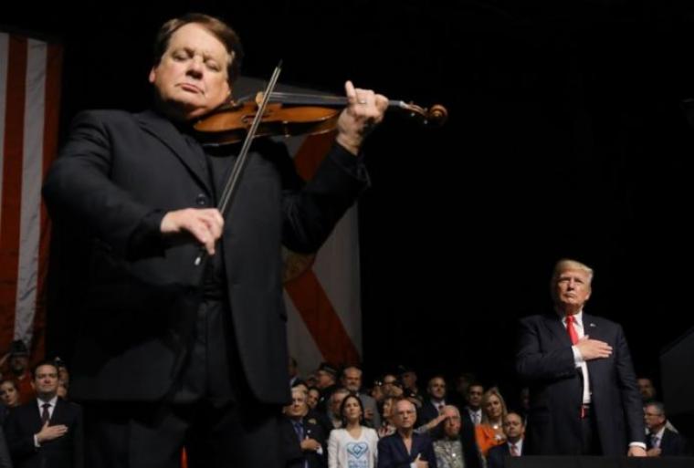 U.S. President Donald Trump listens to Cuban violinist Luis Haza play the US National Anthem after Trump spoke about US-Cuba relations at the Manuel Artime Theater in Miami, Florida, U.S., June 16, 2017.