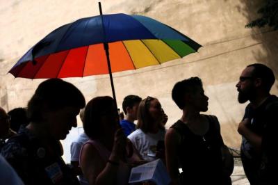 Activists stand under an umbrella in the colors of the LGBT pride flag as they take part in a protest against Westboro Baptist Church members demonstrating nearby in downtown during the 2016 Democratic National Convention in Philadelphia, Pennsylvania July 26, 2016.