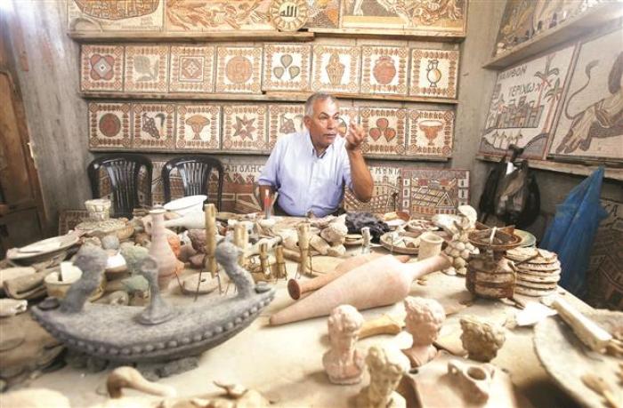 Archaeologist Nafez Abed is seen with the sculptures and intricate mosaics in his workroom in this undated photo.
