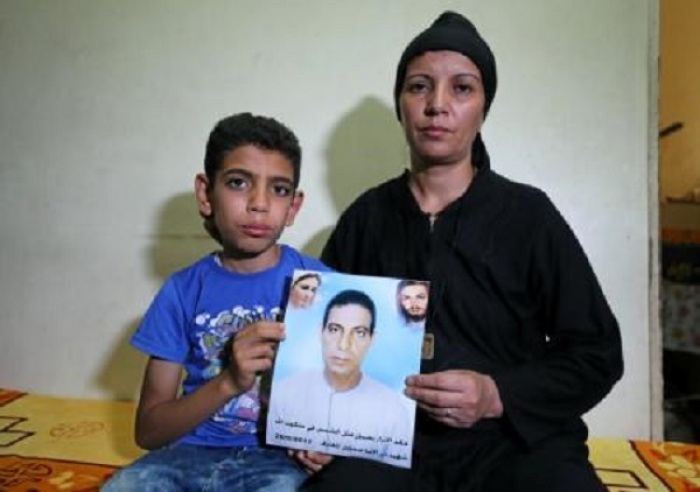 Hanaa Youssef and Mina Habib, the widow and son of a man who was killed in a militant attack against Coptic Christians last month, hold the victim's portrait in Minya, Egypt June 8, 2017. Picture taken June 8, 2017.