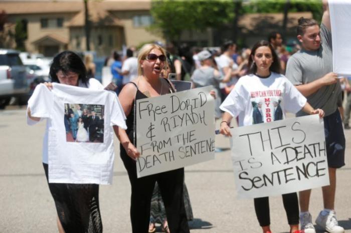 Chaldean-American Nadia Al-Raviah holds a sign protesting against the seizure of her husband and brother Sunday by Immigration and Customs Enforcement agents during a rally outside the Mother of God Chaldean church in Southfield, Michigan, U.S., June 12, 2017.