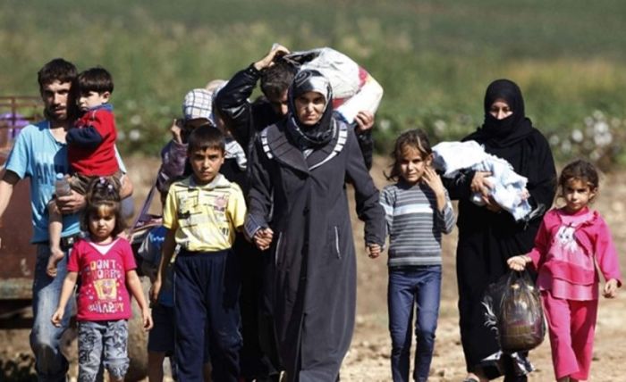 Syrian refugees walk towards the Turkish border to join thousands of other Syrians living in refugee camps. (Reuters)