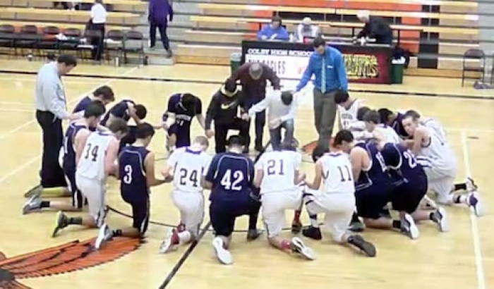Players and coaches from Cheylin High School and Weskan High School boys basketball teams unite for prayer following a game on in Bird City, Kansas, on January 31, 2017.