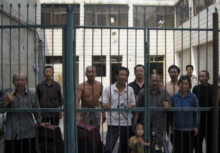 Detainees stand behind prison gates in Nanyang on the outskirts of Beijing.