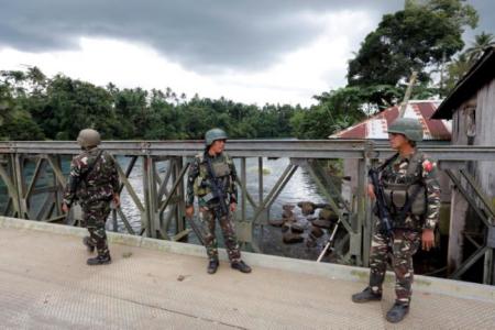 Philippines army soldiers guard a bridge during an operation to retrieve bodies of casualties from the fighting zone in Marawi City, Philippines, June 28, 2017.