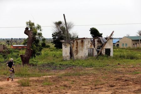 A woman walks toward a house damaged by Boko Haram militants, along the Konduga-Bama road in Bama, Borno, Nigeria, August 31, 2016.