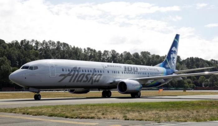 An Alaska Airlines plan rides on a runway. 