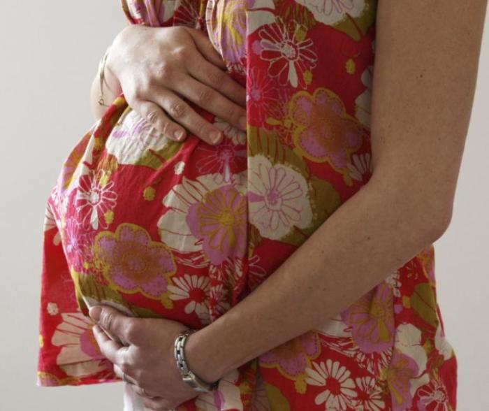 A woman holds her stomach at the last stages of her pregnancy in Bordeaux, April 28, 2010.