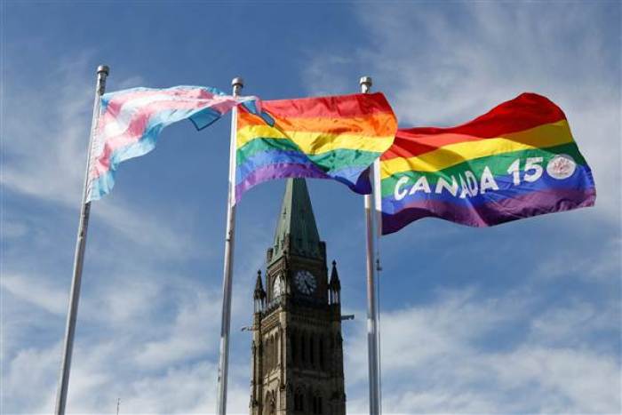 The transgender pride (L), pride (C) and Canada 150 pride flags fly following a flag raising ceremony on Parliament Hill in Ottawa, Ontario, Canada, June 14, 2017.