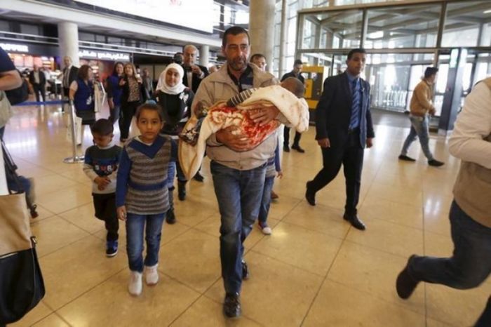 Syrian refugee Ahmad al Aboud and his family members walk to board their plane in Amman, Jordan in April 2016 bound for the United States. | (PHOTO: REUTERS/MUHAMMAD HAMED)