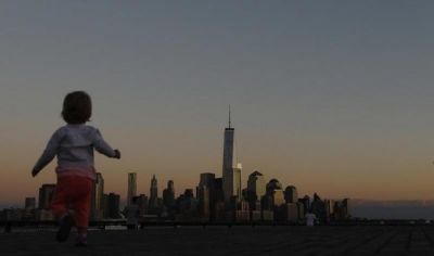 A girl plays in front of the skyline of New York's Lower Manhattan and One World Trade Center in a park along the Hudson River in Hoboken, New Jersey, on Sept. 5, 2013.