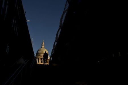 A City worker walks near St. Paul's Cathedral in the City of London, December 15, 2014.