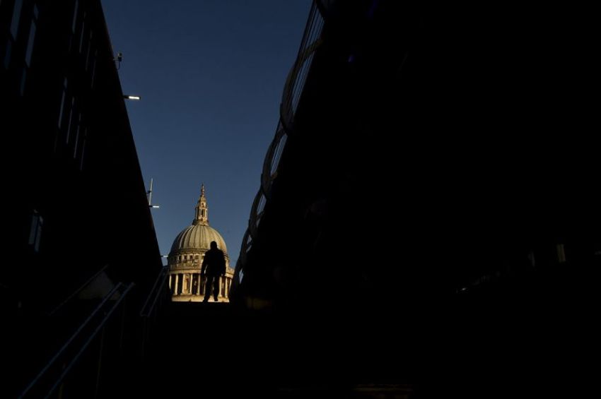 A City worker walks near St. Paul's Cathedral in the City of London, December 15, 2014.