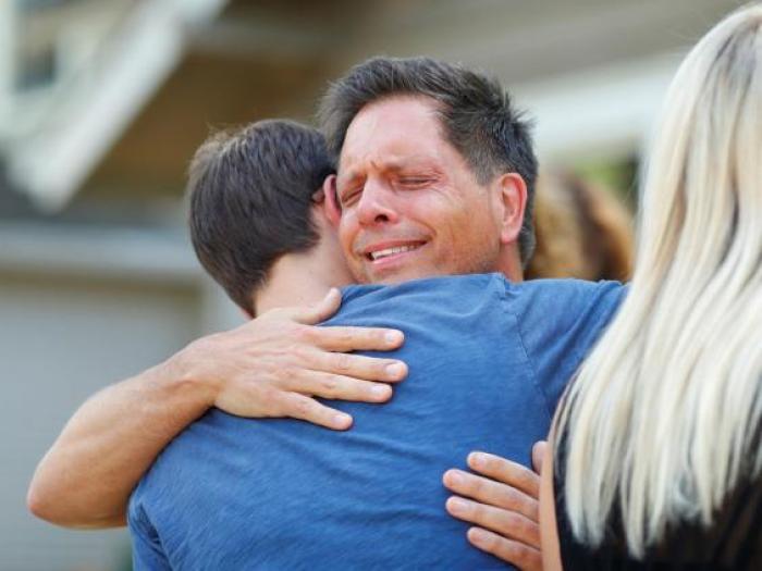 Don Damond hugs a neighbour after reading a statement about his fiance, July 17, 2017.