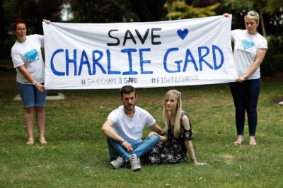 The parents of critically ill baby Charlie Gard, Connie Yates and Chris Gard, pose for photographers as supporters hold a banner, before delivering a petition to Great Ormond Street Hospital, in central London, Britain July 9, 2017.