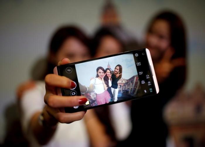 Models pose for photographs with a LG electronics' new V20 premium smartphone during its unveiling ceremony in Seoul, South Korea, September 7, 2016.