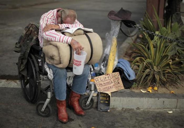 A homeless man begs for money in downtown Los Angeles, California, August 22, 2011.