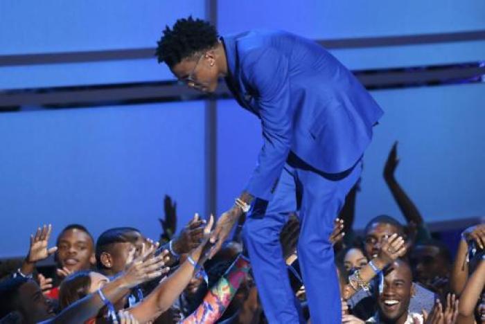 August Alsina is congratulated as he takes the stage to accept the award for best new artist during the 2014 BET Awards in Los Angeles, California on June 29, 2014.