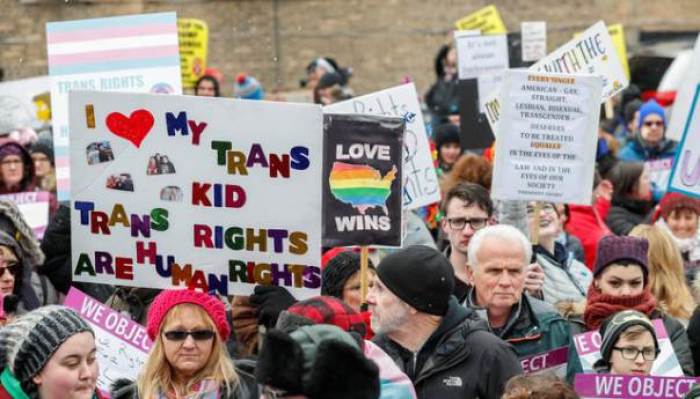 Demonstrators hold signs during 'Stand Up for Transgender Rights' event to show their support for transgender equality, in Chicago, Illinois, U.S. February 25, 2017.
