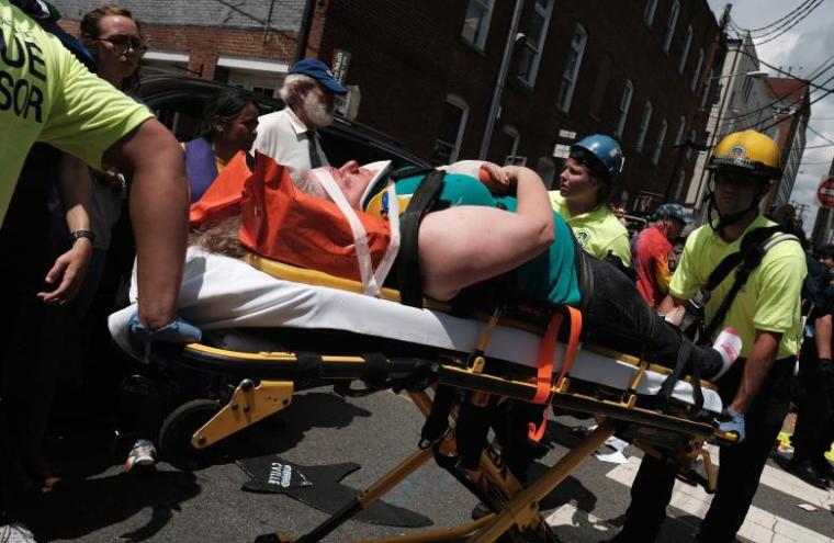 Rescue workers transport a victim who was injured when a car drove through a group of counter protesters at a KKK rally in Charlottesville, Virginia, August 12, 2017.