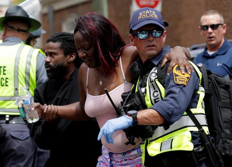 Rescue workers assist a victim who was injured when a car drove through a group of counter protestors at a KKK rally in Charlottesville, Virginia, August 12, 2017.