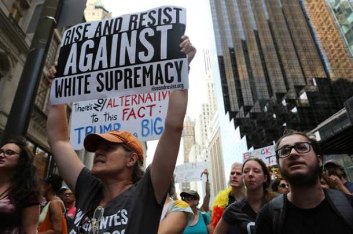 Protesters hold signs and chant slogans during a march against white nationalism outside Trump Tower in New York City, U.S., August 13, 2017.