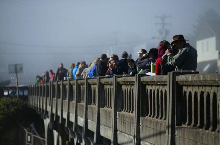 People line up on a bridge as the sun emerges through fog cover before the solar eclipse in Depoe Bay, Oregon, U.S., August 21, 2017. Location coordinates for this image are 44°48'38' N 124°3'40' W.