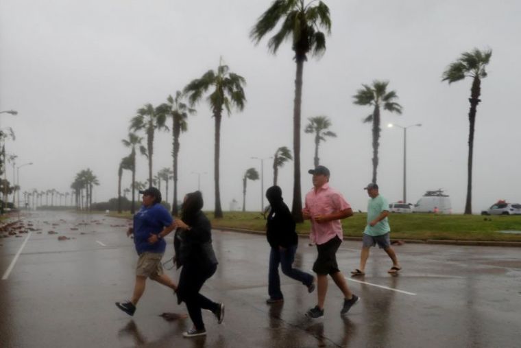 A group of people race across the street as winds from Hurricane Harvey escalated in Corpus Christi, Texas, U.S. August 25, 2017.