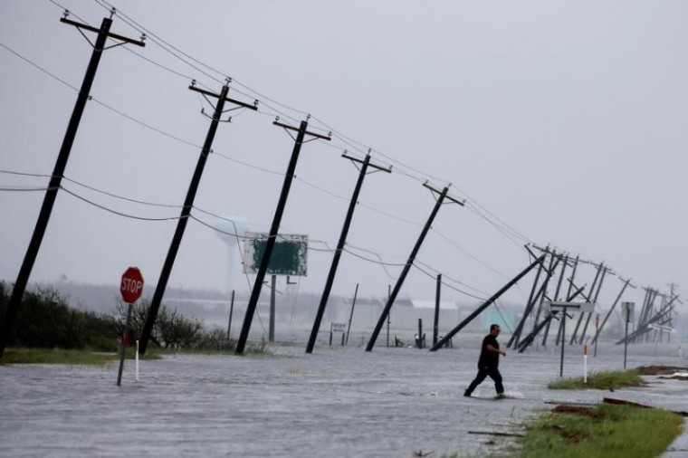 A man walks through floods waters and onto the main road after surveying his property which was hit by Hurricane Harvey in Rockport, Texas, U.S. August 26, 2017.