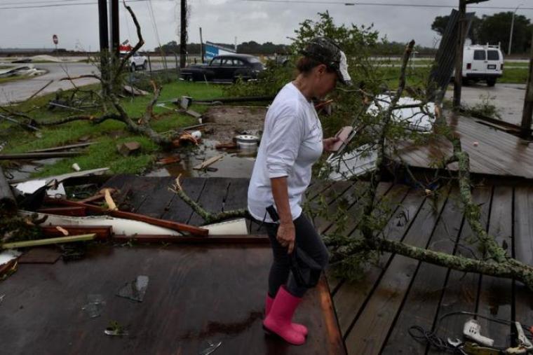 Gloria Bryant looks through damage on her property caused by a tornado that spun off of Hurricane Harvey after the storm made landfall on the Texas Gulf coast, in Katy, Texas, U.S. August 26, 2017.