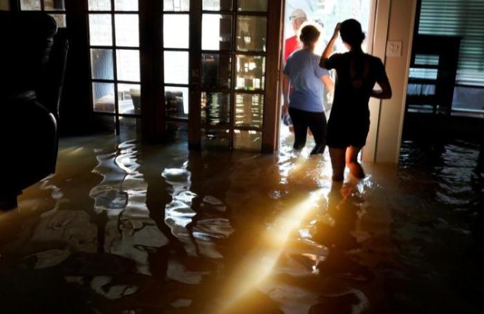 A family that wanted to remain anonymous moves belongings from their home flooded by Harvey in Houston, Texas August 31, 2017.