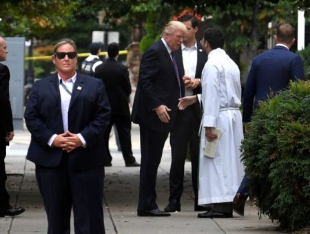 President Donald Trump is greeted by Assistant Rector D. Andrew Olivo as he arrives at St. John's Episcopal Church at Lafayette Square, across from the White House, for a national